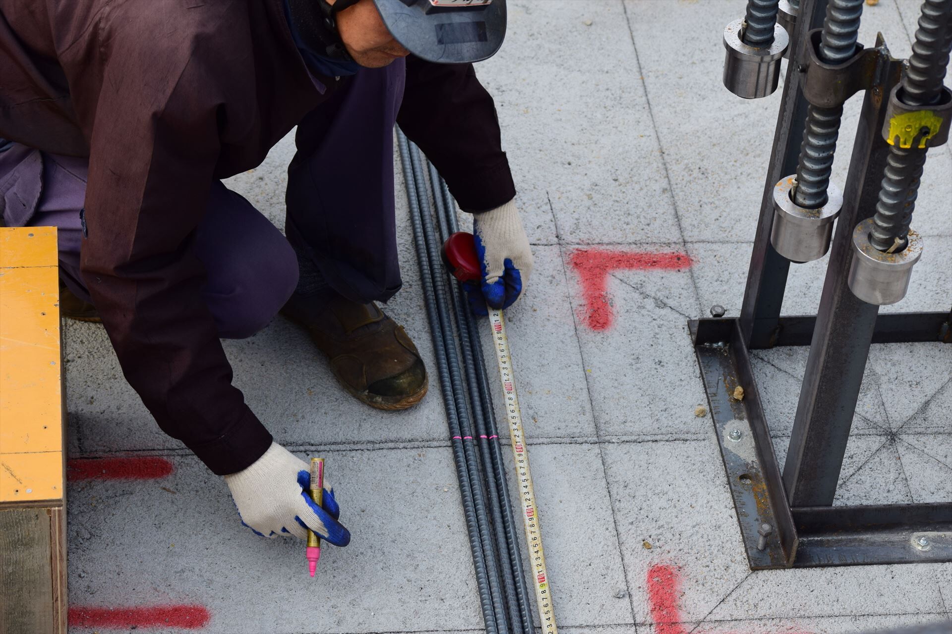鉄筋の長さを測る職人